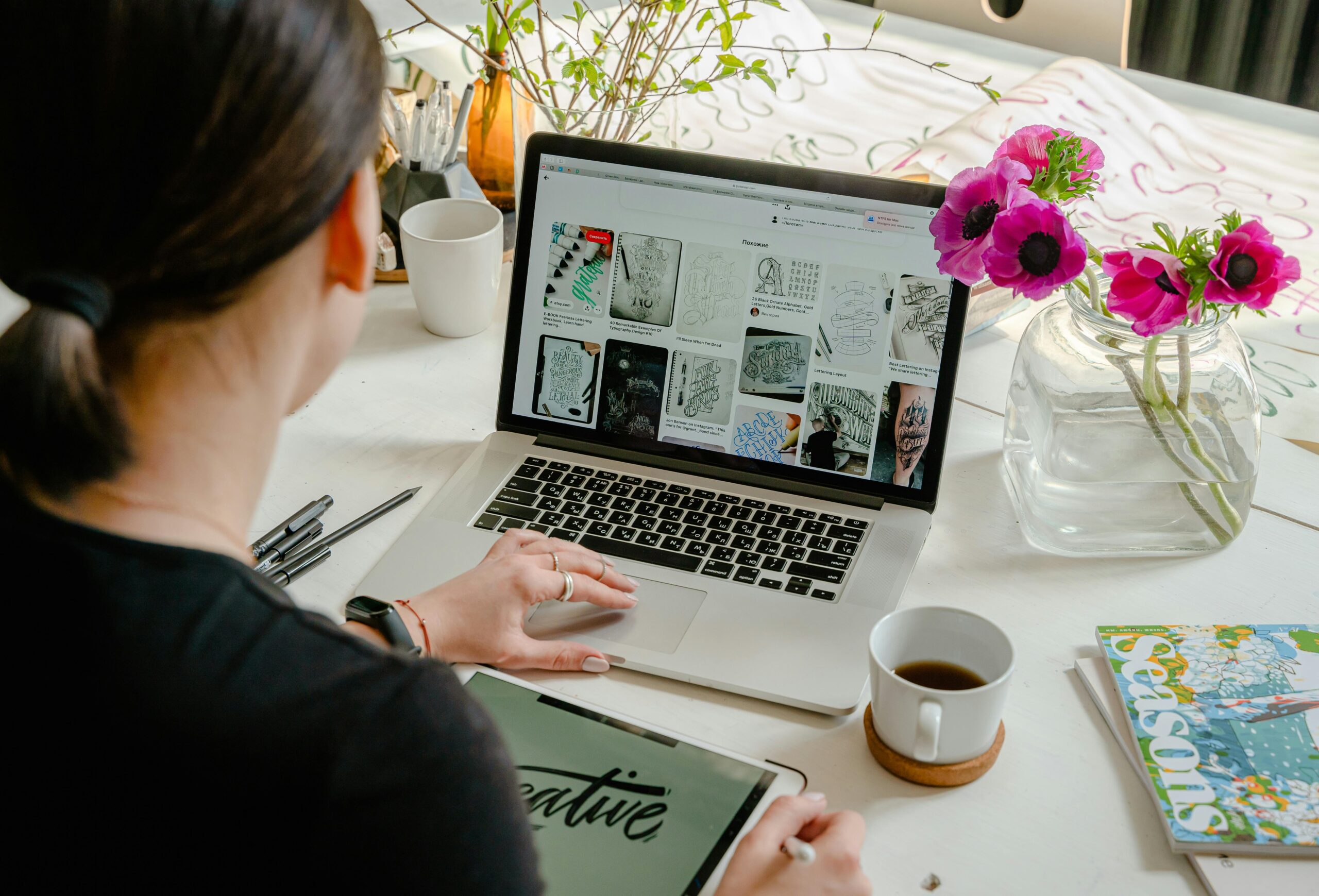 A woman sitting at her desk, working on her computer using a CRM